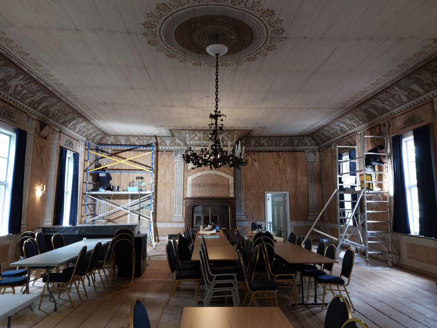 Museets konservatorer arbetar med väggmålningar från 1800-talet i Stora matsalen på Medevi Brunn.