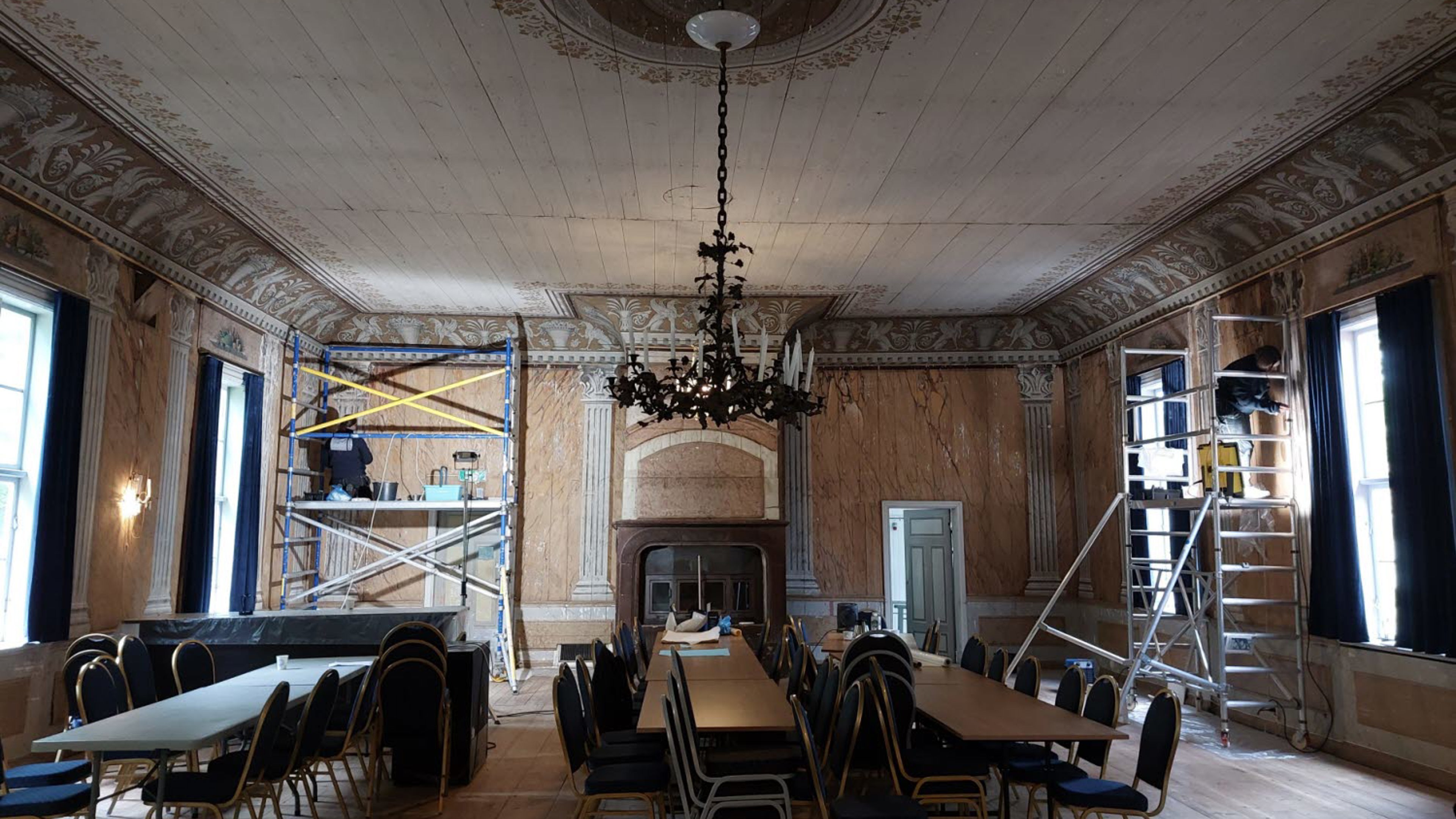 Museets konservatorer arbetar med väggmålningar från 1800-talet i Stora matsalen på Medevi Brunn.