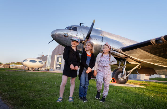 Tre barn framför ett flygplan utanför Flygvapenmuseum.