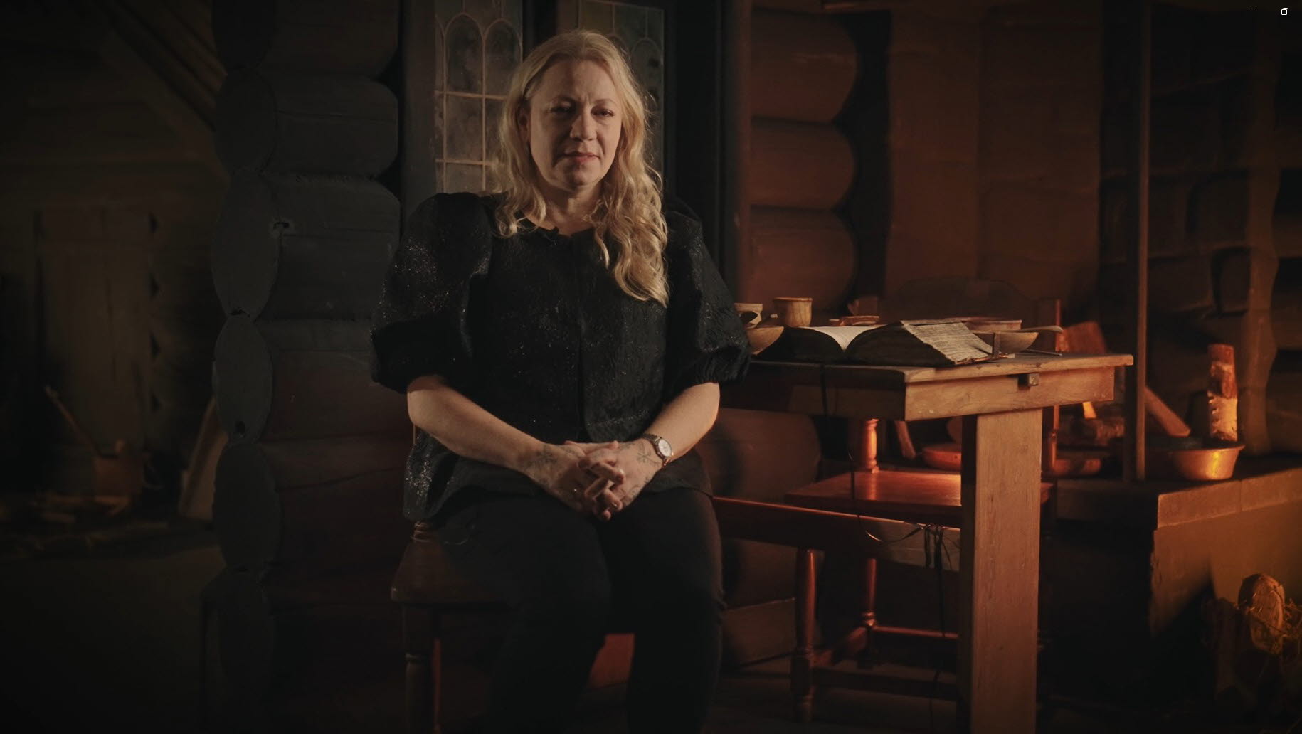 Skärmklipp ur film där museipedagog Mikaela Radakovic Kjäll berättar om Lusse i Svarttorps öde under häxprocessen i Finspång. Filmen är inspelad i utställningen HÄXOR.