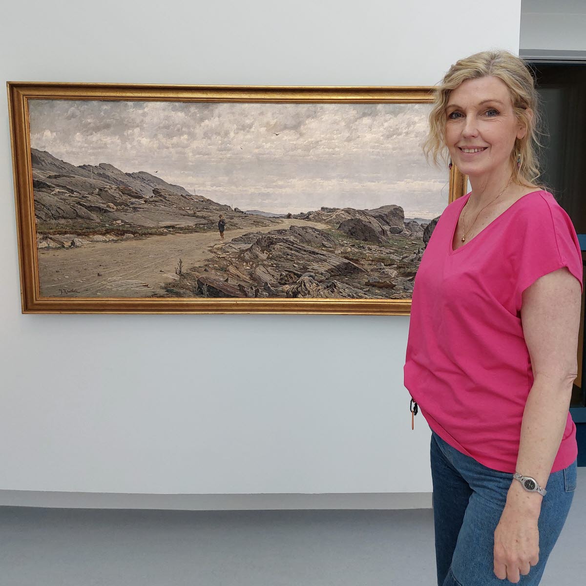 Konstpedagog Åsa Nyberg Botshinda framför en tavla av Johan Krouthén i utställningen Verkligheter .