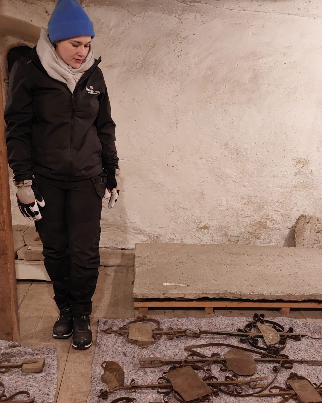 Föremål av sten, trä och järn flyttas från det medeltida stenhuset Rhyzeliusgården i Linköping till ett av museets magasin. Här ses Larissa Borck, enhetschef Samlingar,