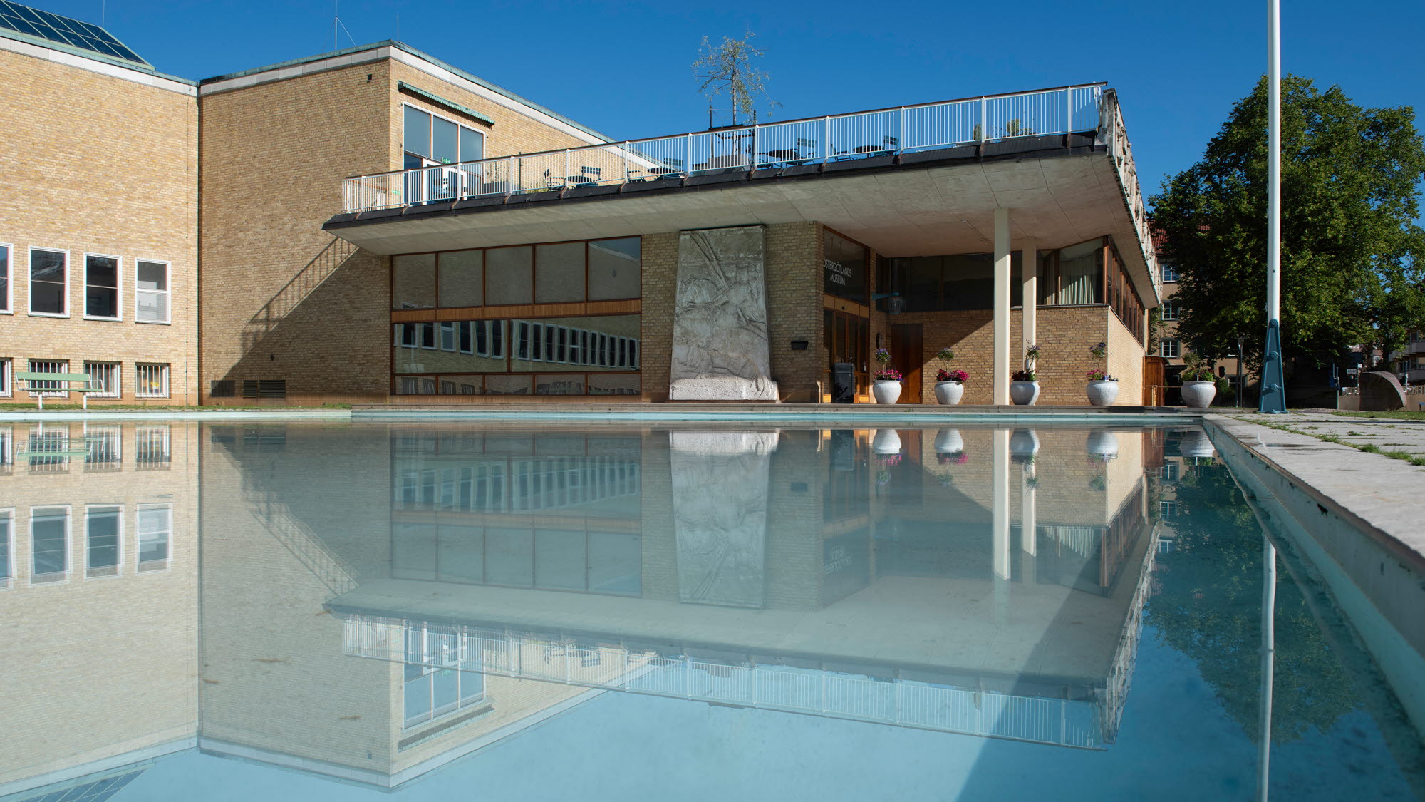 Östergötlands museum med spegeldammen i förgrunden.