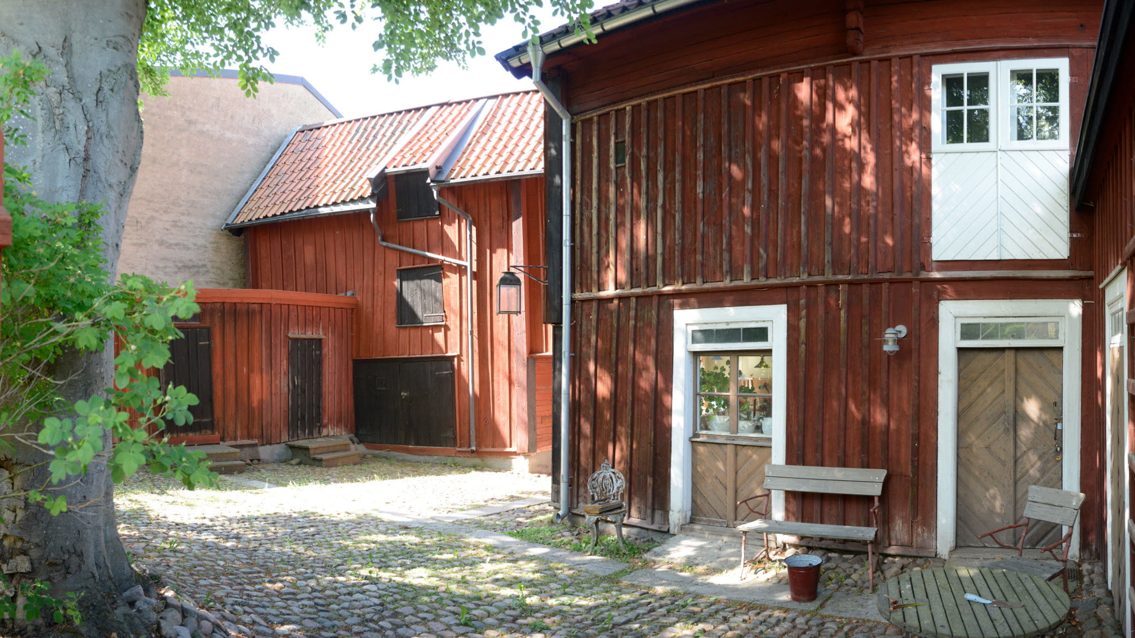 Onkel Adamsgården i Linköping, exteriör, innergården med uthus i forn av röda trähus. 
