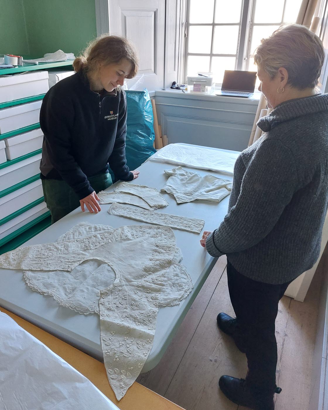 Textilkonservator Anna Djuvfeldt och konservatorsassistent Hanna Carlshamre under arbete med textilier på Löfstad slott.