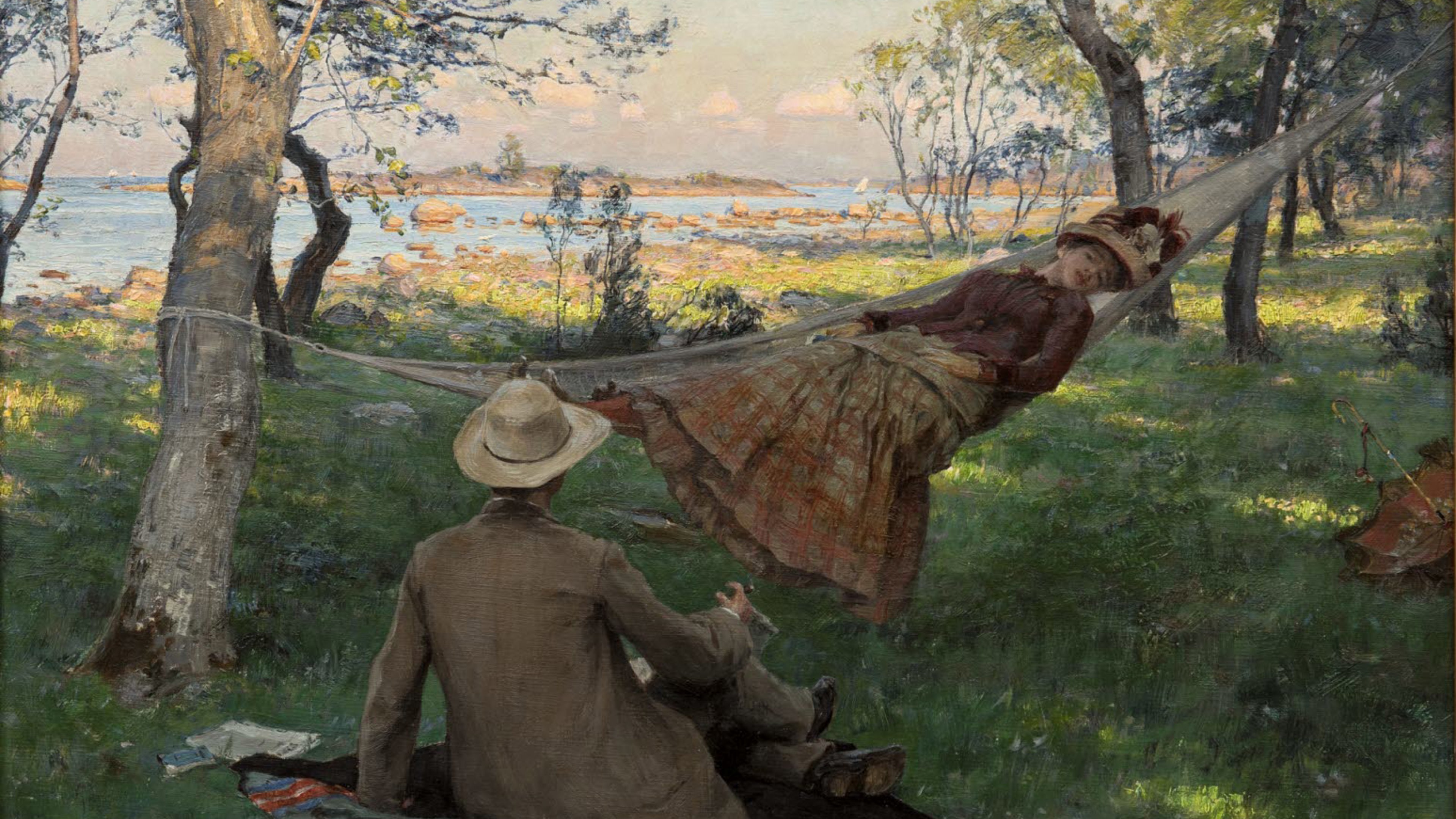 Sommarsiesta av Johan Krouthén. En man sittande på en picknickfält i gräset framför en kvinna liggande i en hängmatta.