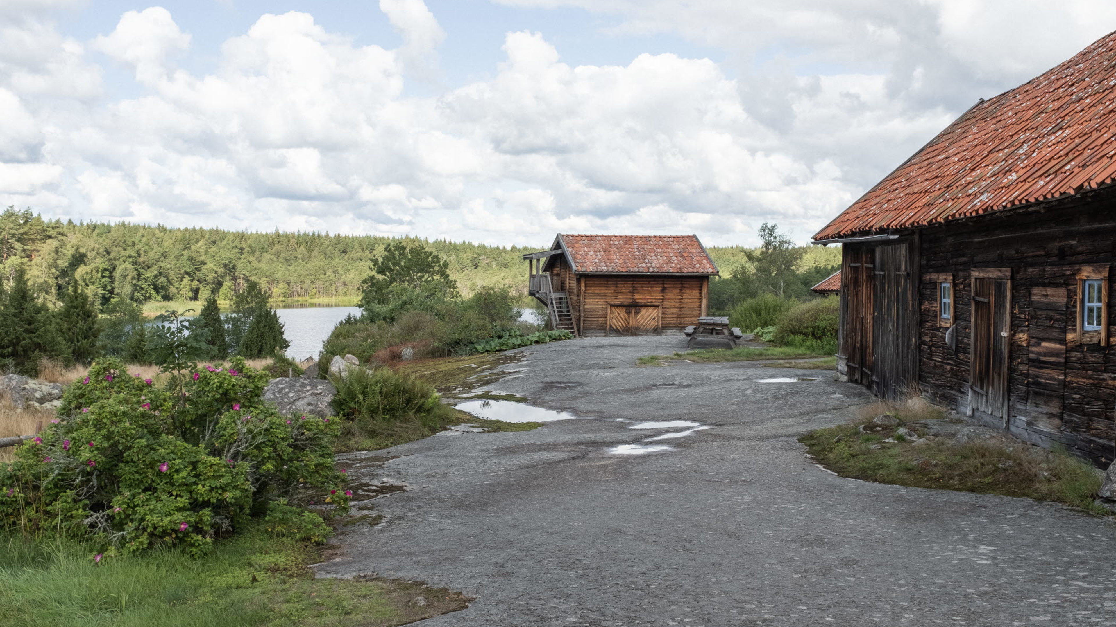 Två trähus intill en sjö 