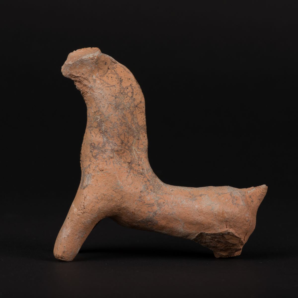 Leksakshäst av bränd lera, med bakben och nos avslagna. Tillvaratagen vid schaktningsarbeten på Pestkyrkogården i Linköping med gravar daterade 1710-1711 där hästen kan ha begravts med någon.