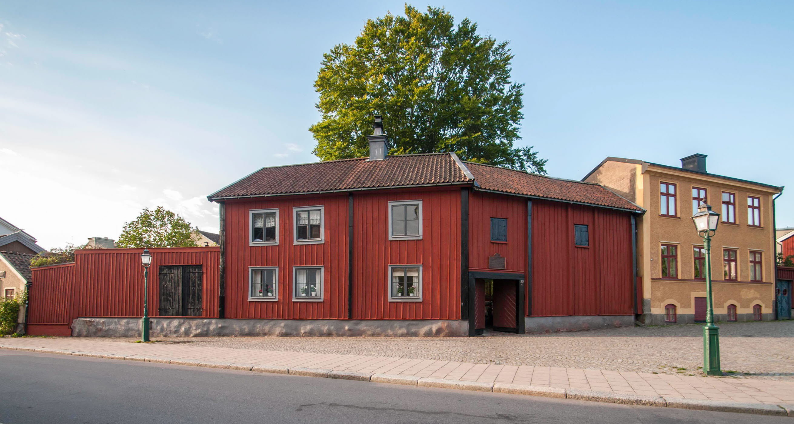 Onkel Adamsgården med sidan röda träbyggnader från gatusidan.