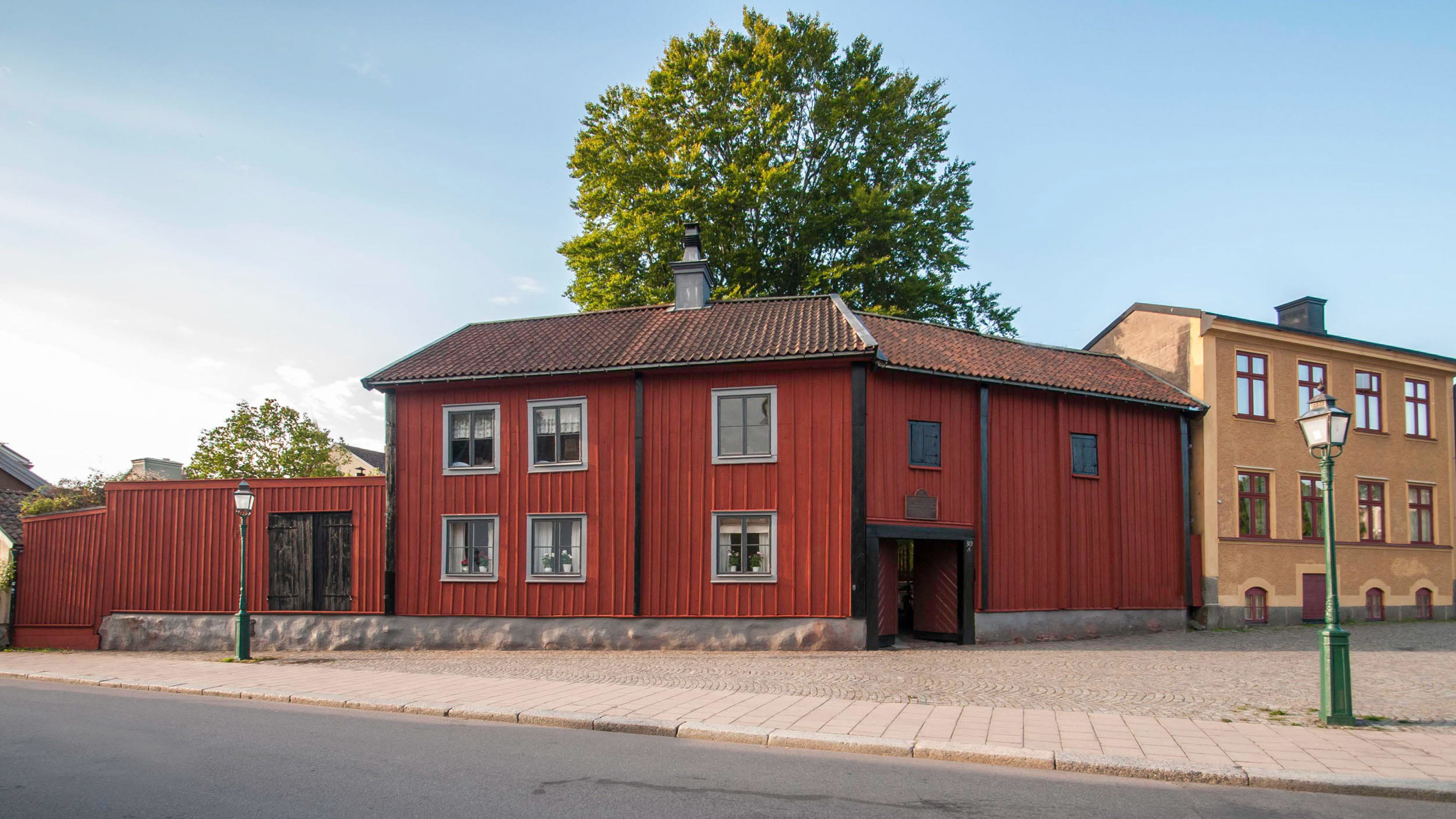 Onkel Adamsgården med sidan röda träbyggnader från gatusidan.