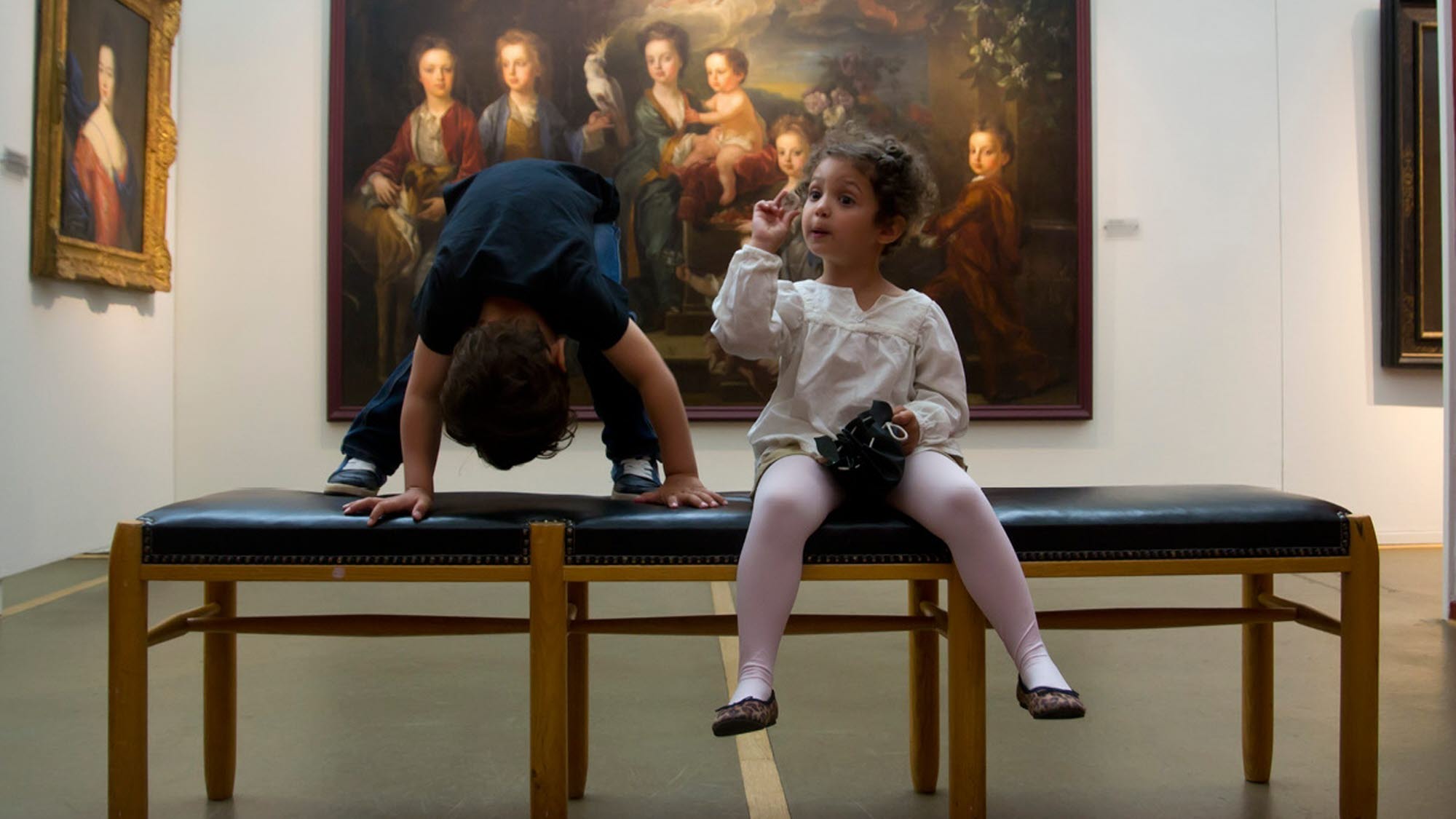 Barn framför tavlor