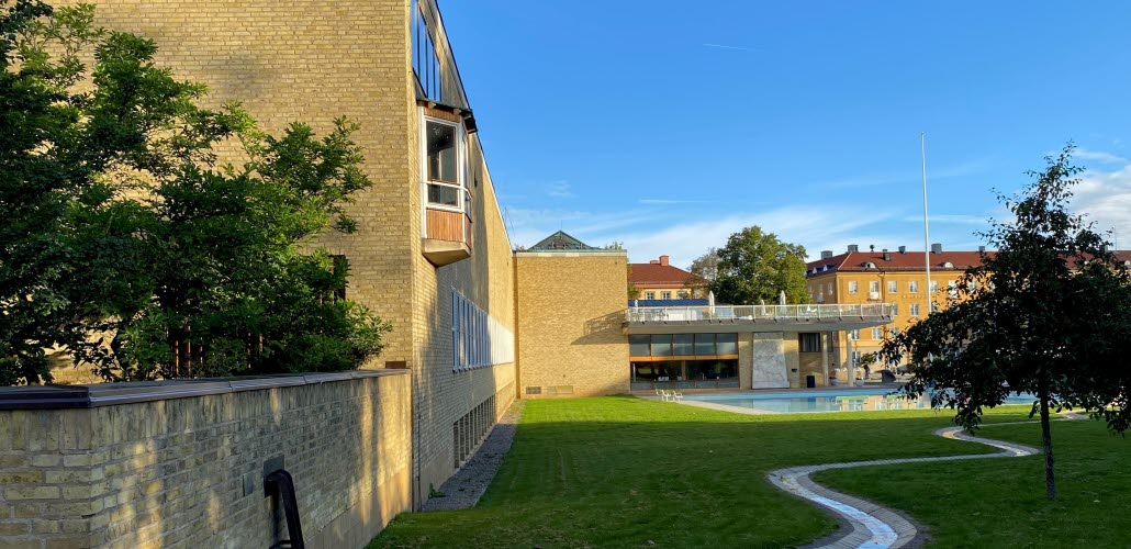 Exteriörbild på Östergötlands museum och dess vattenspegel, sett från parken.