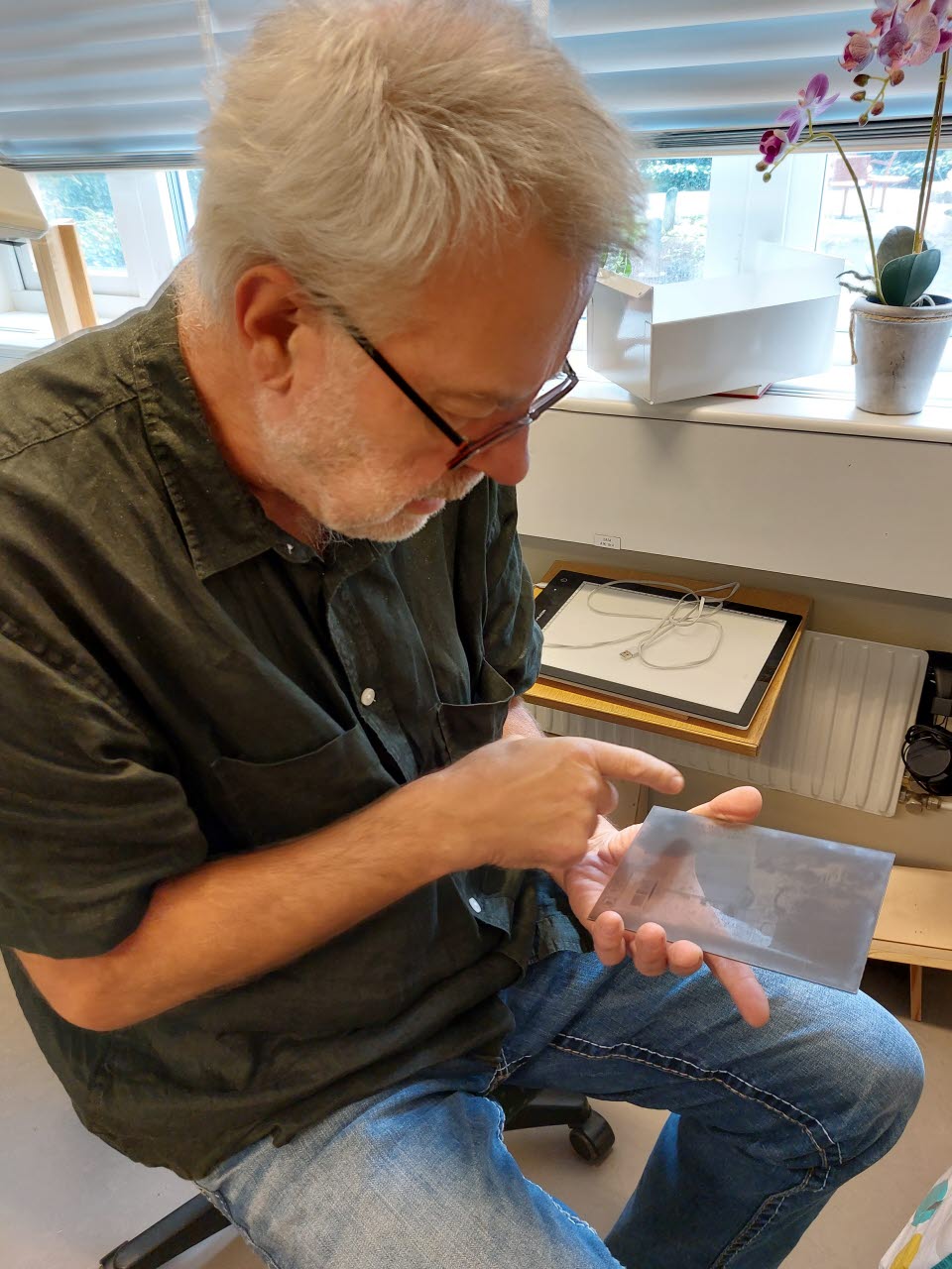 Leif Wallentinsson visar upp en glasplåt från en nyinkommen fotosamling.
