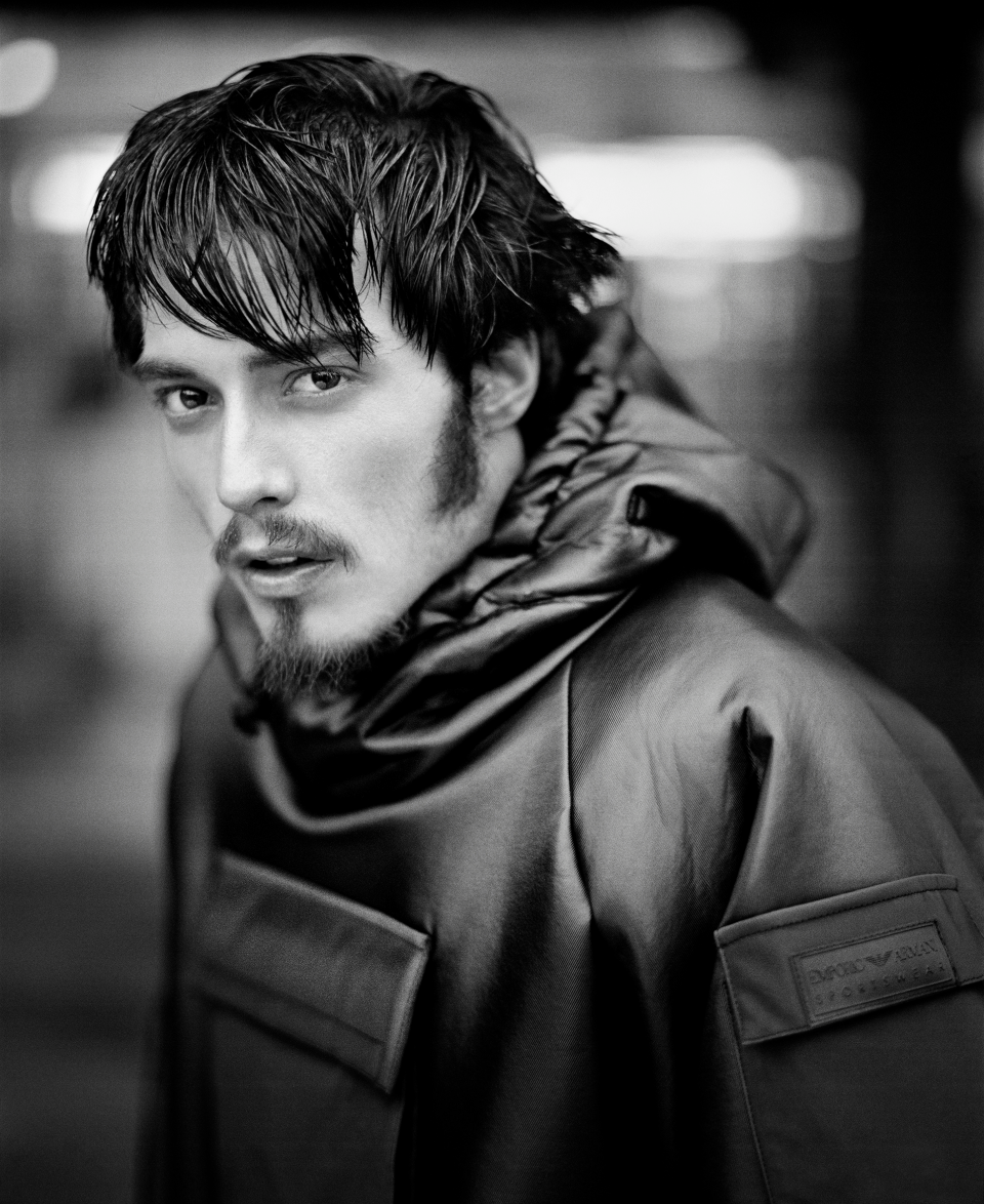 Ung man i blank jacka med huva