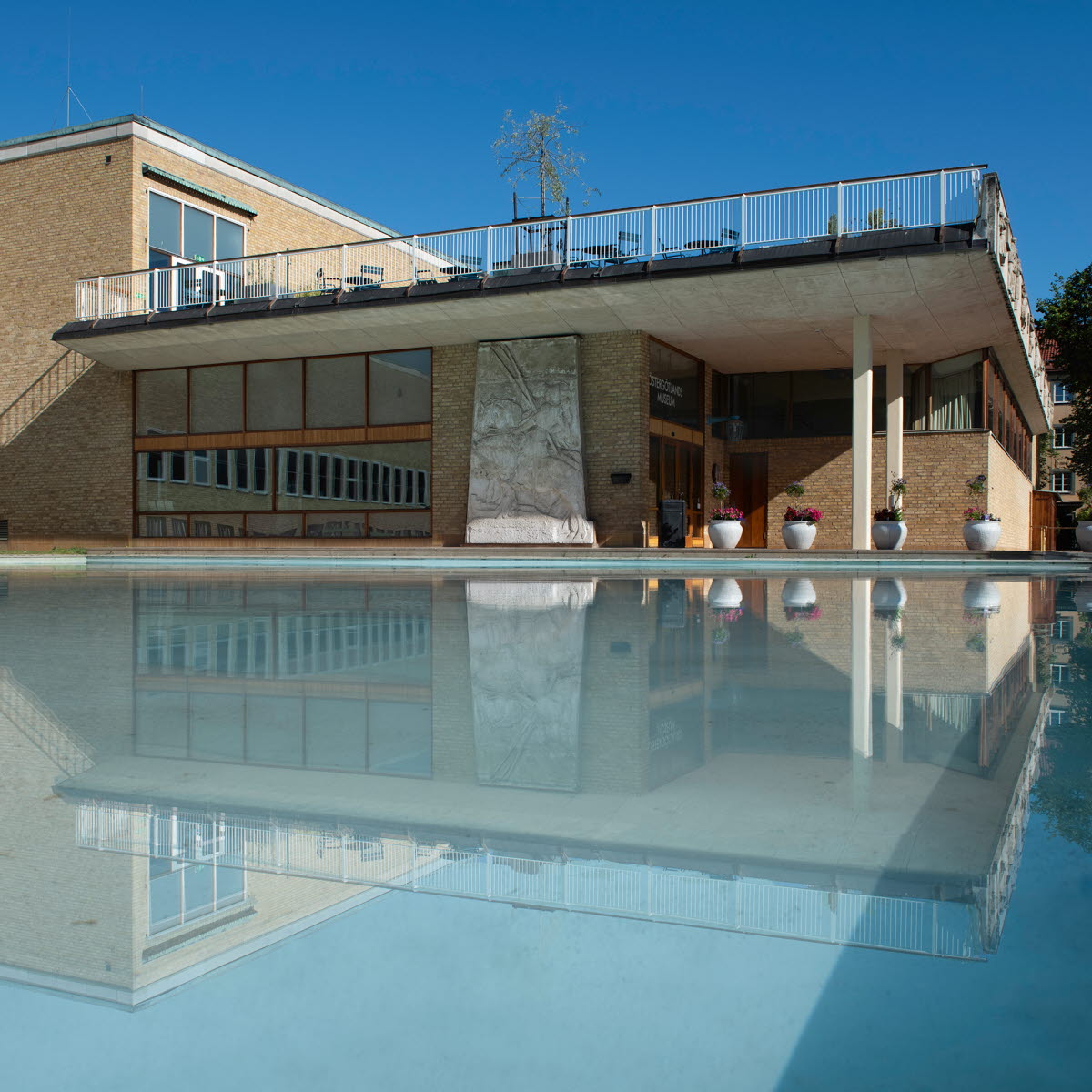 Östergötlands museum med spegeldammen i förgrunden.